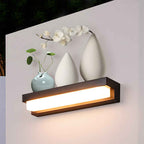 Wall-mounted light fixture with decorative vases and flowers on a white wall.