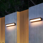 Two modern outdoor wall lights on a building facade at night.