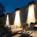 Outdoor patio with seating area, lighting fixtures, and plants at night.