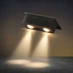 Wall-mounted outdoor light fixture emitting a warm glow on a dark background