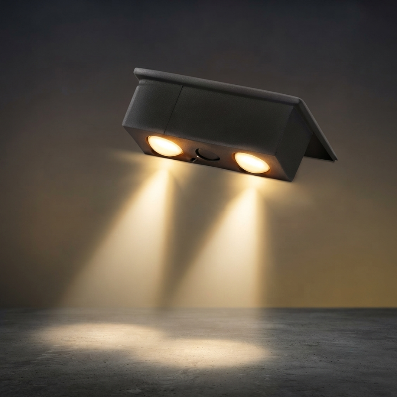 Wall-mounted outdoor light fixture emitting a warm glow on a dark background
