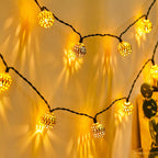 String of decorative lights with glowing bulbs on a yellow background