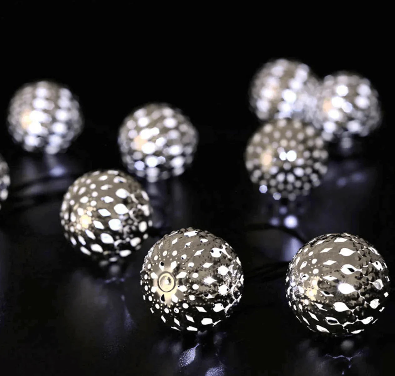 Silver disco ball string lights on a black background