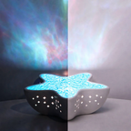 Star-shaped night light projecting a colorful nebula pattern on a wall.