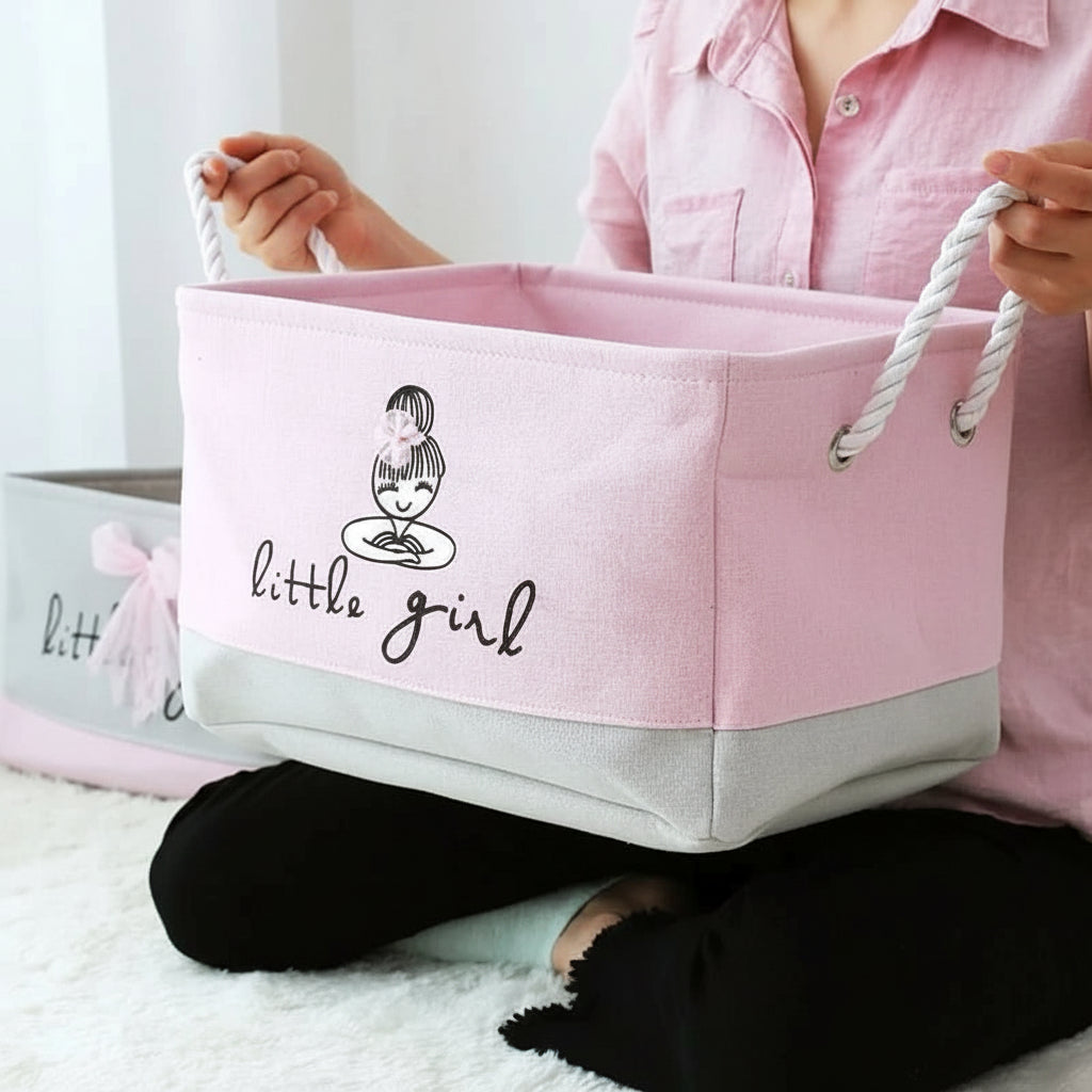 Person holding a pink storage basket with 'little girl' text and logo.