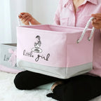 Person holding a pink storage basket with 'little girl' text and logo.