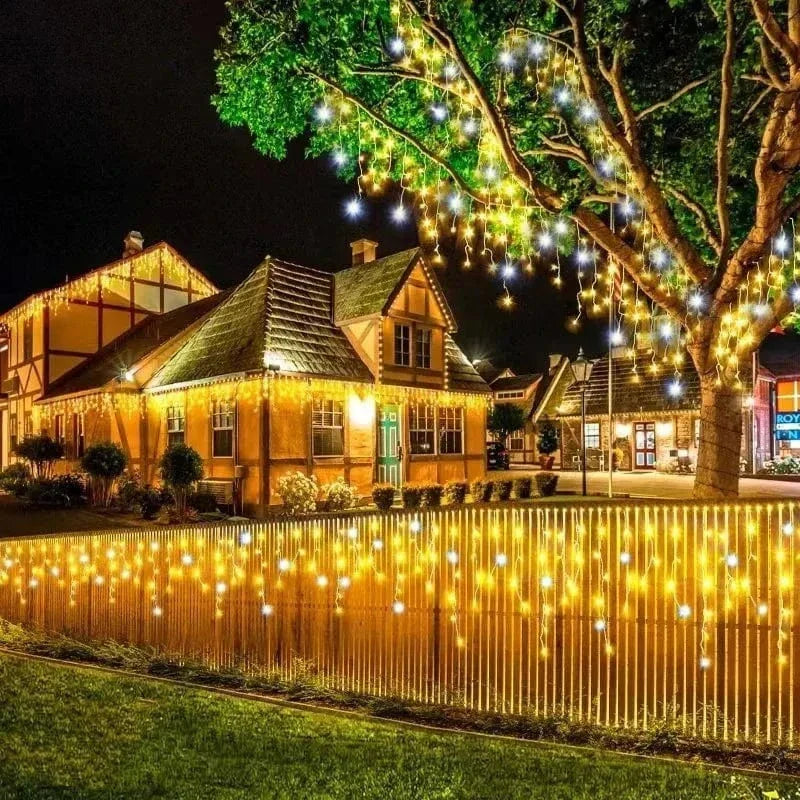 Wooden house with string lights on a tree and fence at night