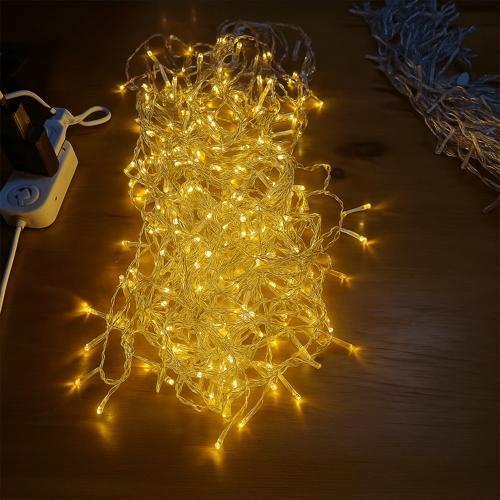 String of lights on a wooden surface with a power adapter.