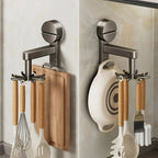 Wall-mounted kitchen organizer with cutting board, whisk, spatula, and other utensils.