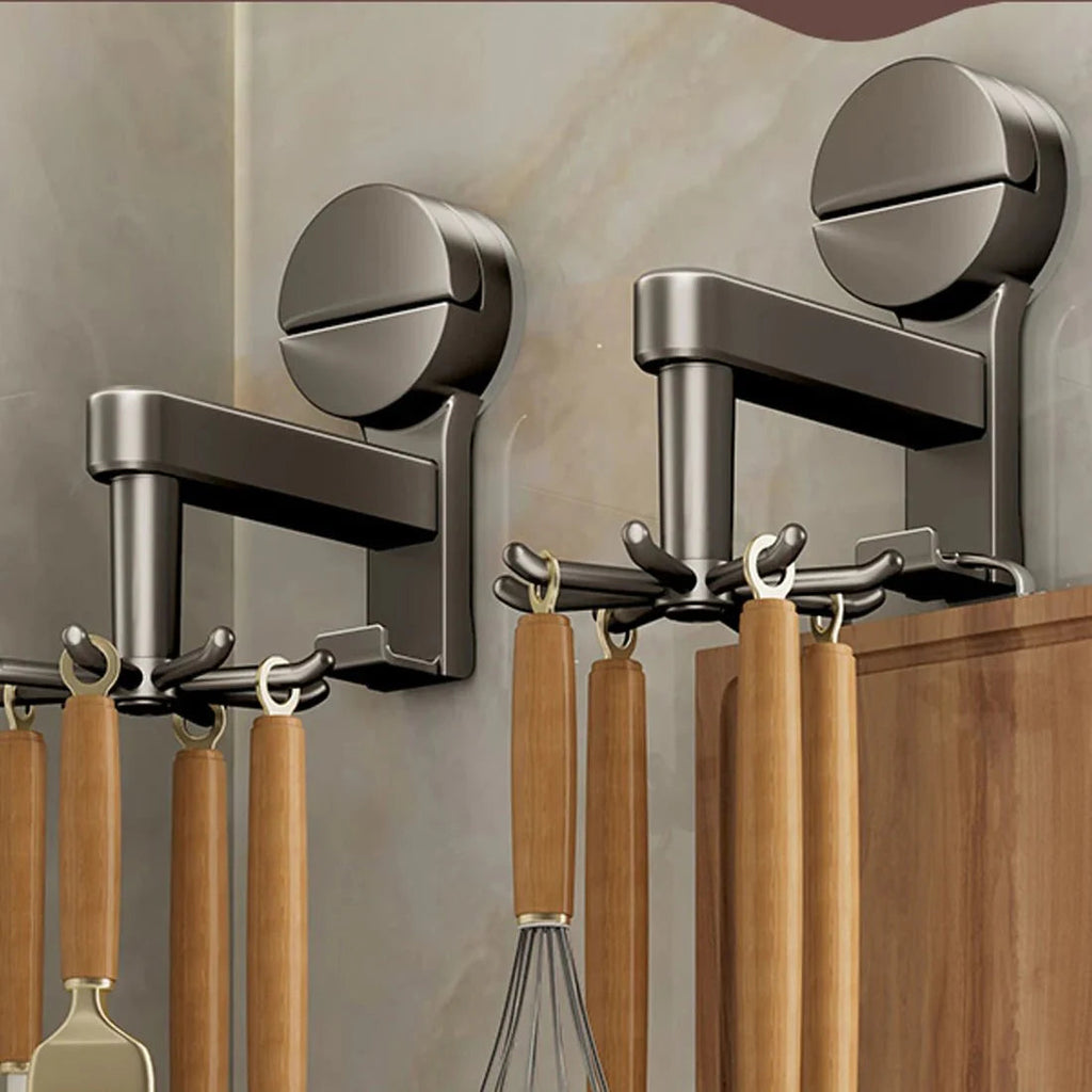 Wall-mounted metal hooks with wooden utensils against a neutral wall.