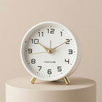 White clock with gold accents on a beige background