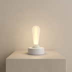 White light bulb on a white base against a beige background