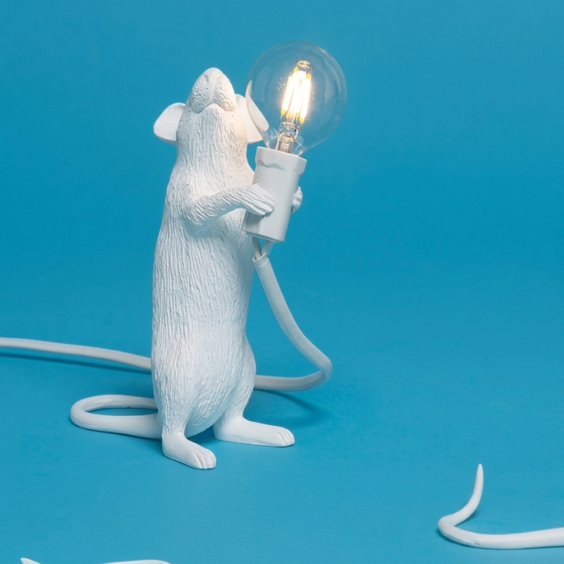 White mouse-shaped lamp holding a light bulb on a blue background