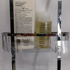 Shampoo bottle and bottle of conditioner on a clear shower caddy with a white background