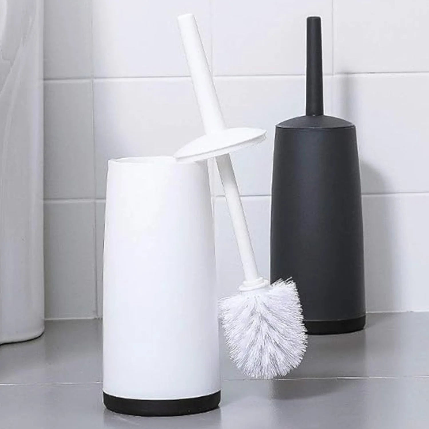 Two toilet brushes, one white and one black, against a tiled bathroom wall.