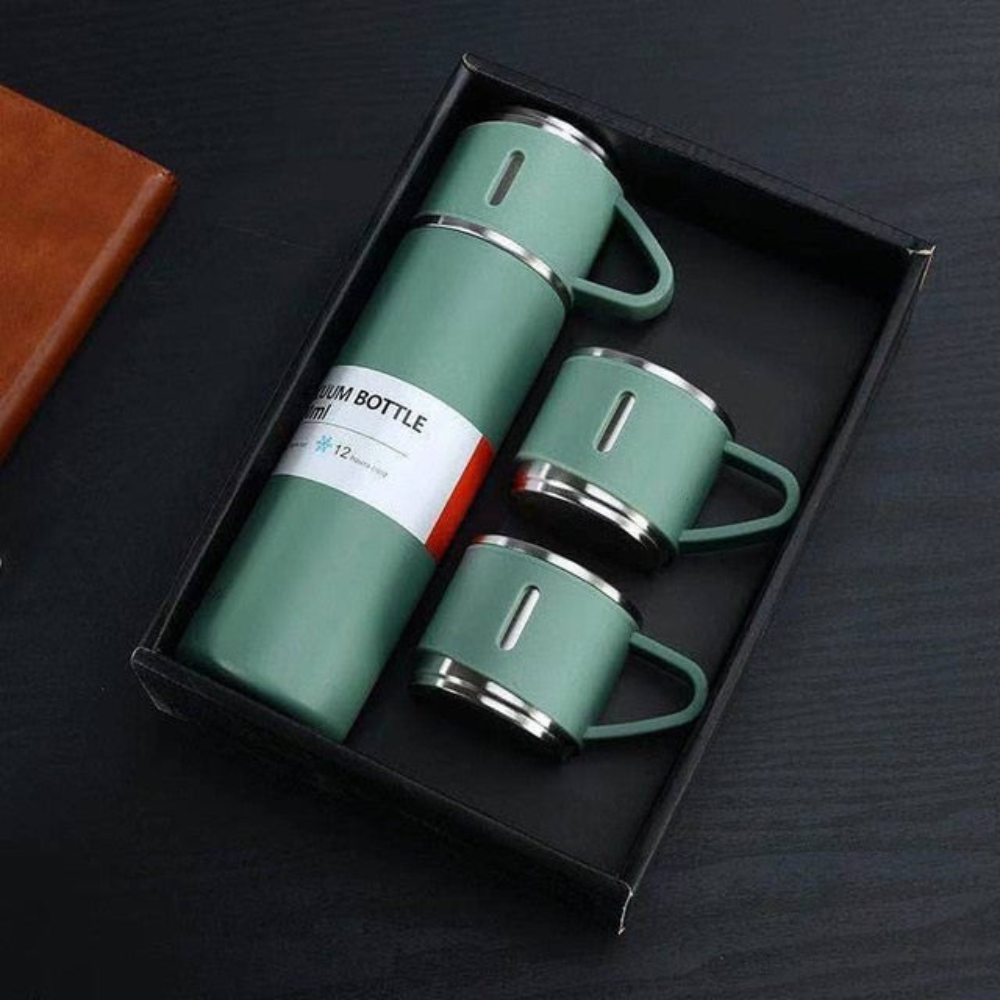 Green thermos bottle and mugs set in a black box on a dark surface