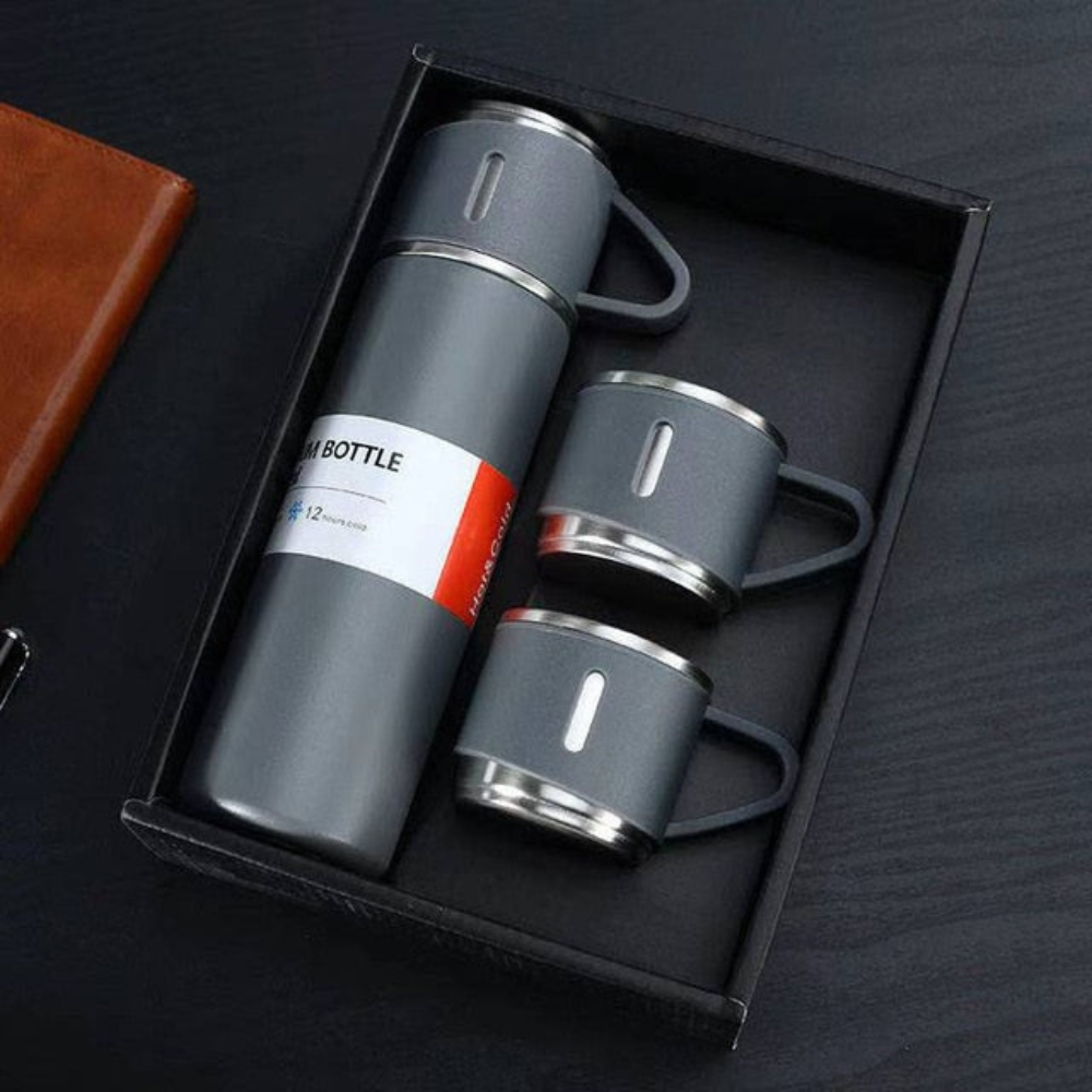 Gray insulated bottle and mugs set in a black box on a dark surface