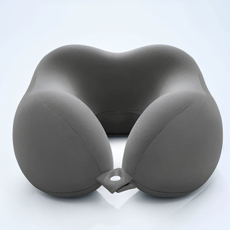 A dark gray inflatable neck pillow with a contoured shape, featuring two rounded sides and a small attachment loop at the bottom, shown on a light gray reflective studio background.