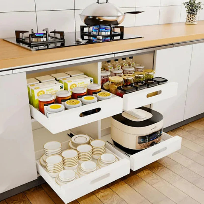 Kitchen island with pull-out drawers containing kitchen items like jars, bowls, and a rice cooker.