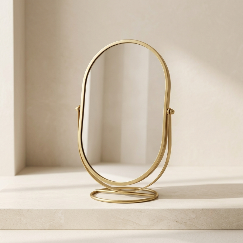 Gold stand-up mirror on a neutral background