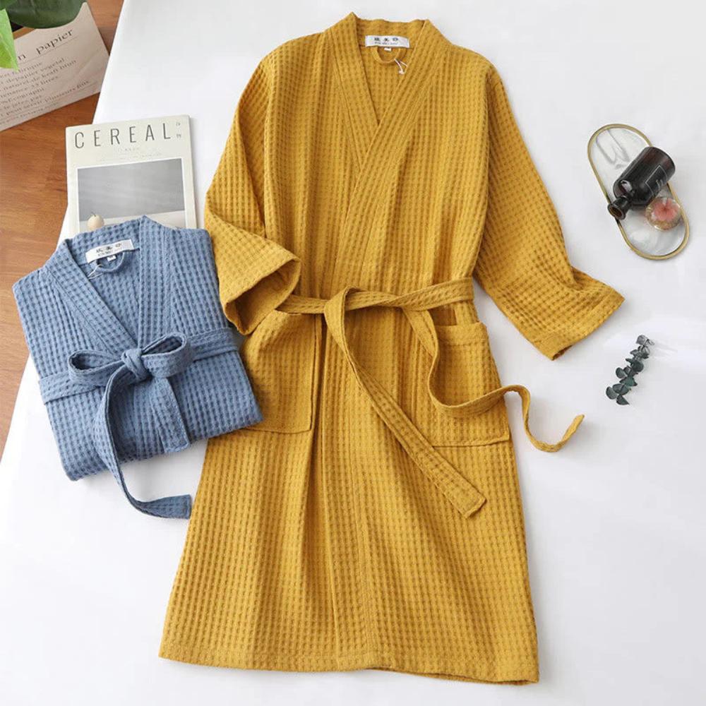 Yellow and blue textured robes on a white surface with a cereal box and other items.