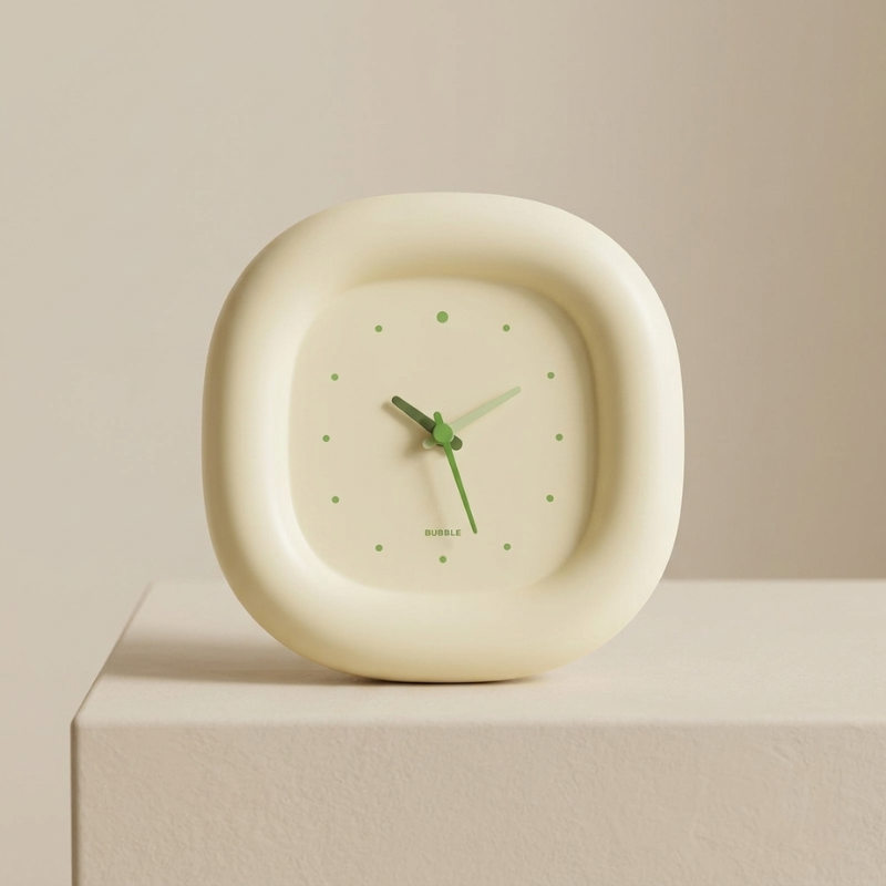 Cream-colored clock with green hands on a beige surface and background