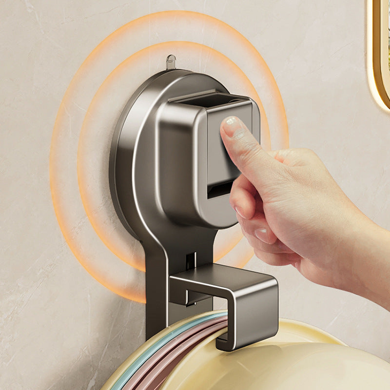 Hand pressing a modern soap dispenser on a bathroom wall.