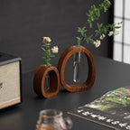 Two wooden vases with plants on a dark surface