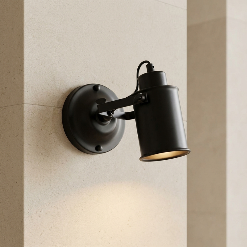 Black wall-mounted lamp on a beige wall