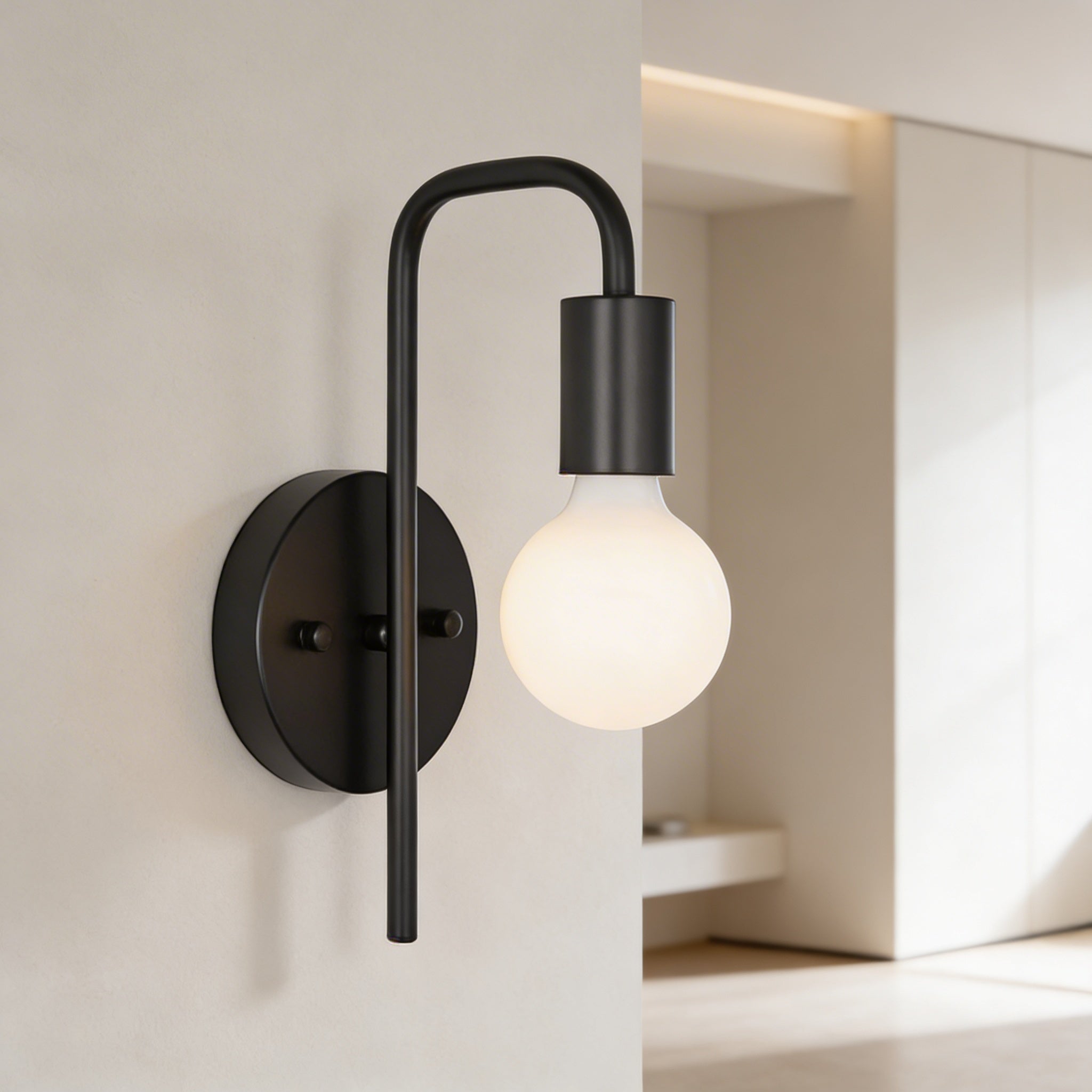 Modern wall-mounted light fixture with a black arm and white bulb on a neutral background