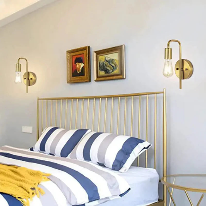 Gold metal bed frame with striped bedding in a bedroom setting.