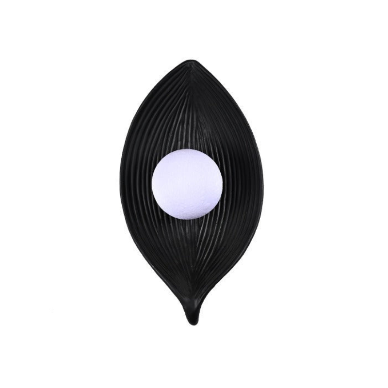 A modern black leaf-shaped wall sconce with a ribbed texture and a central frosted white glass globe, shown against a plain white background.