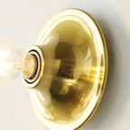 Gold wall sconce with a light bulb on a white background