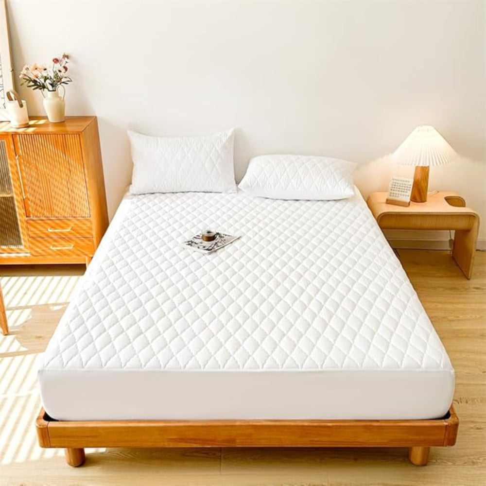 White mattress cover on a wooden bed in a bedroom setting
