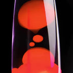 Close-up of a lava lamp with red and orange colors on a black background