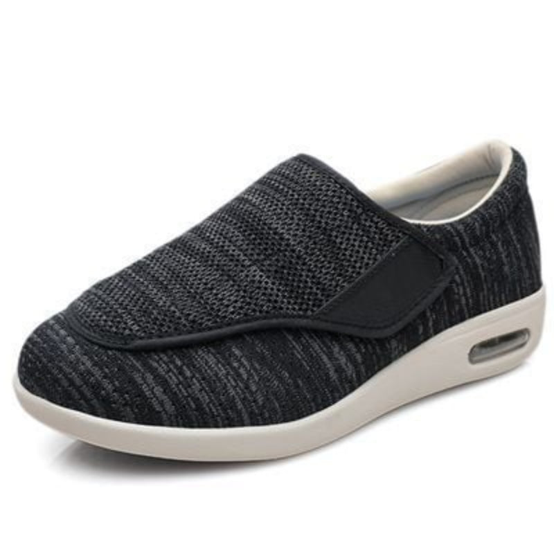 Black slip-on shoe with white sole on a white background
