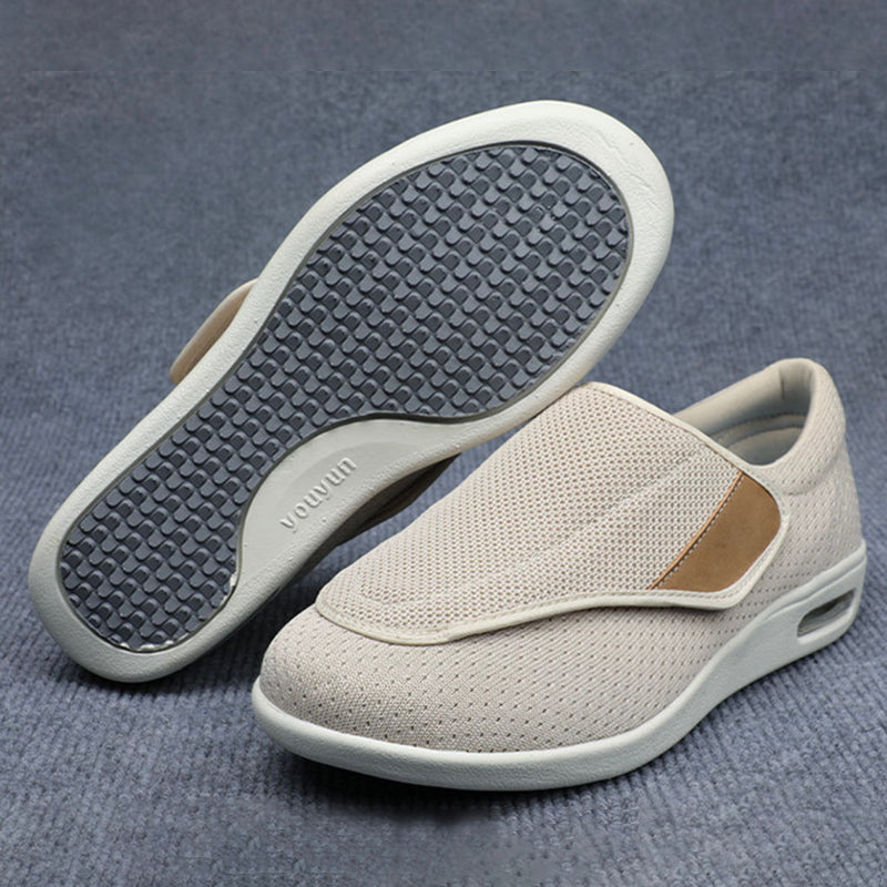 Pair of light gray slip-on shoes with a textured sole on a blue background