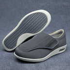 Gray slip-on shoes with white soles on a gray background