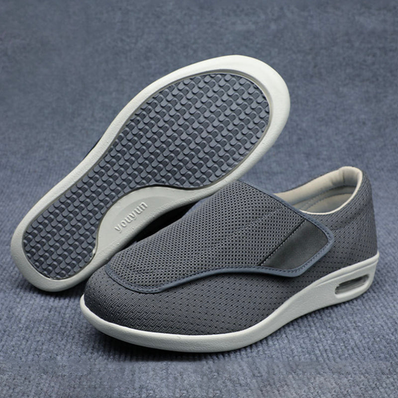 Gray slip-on shoes with white soles on a gray background