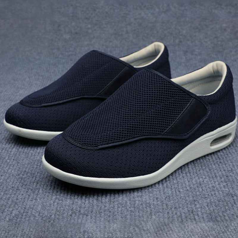 Pair of navy slip-on shoes with white soles on a gray background