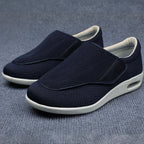 Pair of navy slip-on shoes with white soles on a gray background