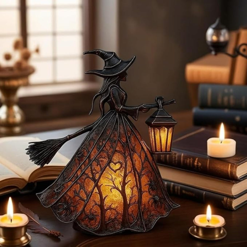 Decorative witch figurine with a lantern on a table with candles and books.