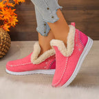 Pink winter slip-on shoes with fluffy cream faux-fur trim, shown on a model wearing light blue jeans. The shoes feature white soles and decorative stitching.