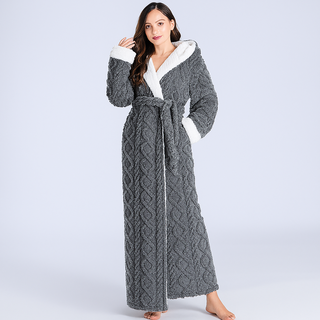 Woman wearing a gray cable knit robe with white trim on a light gray background