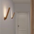 Modern wall sconces on a white wall with a door in the background