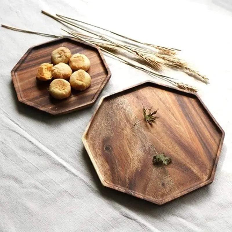 Two wooden hexagonal trays on a light surface with small items and dried plants.