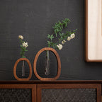 Two wooden wall-mounted vases with plants against a dark gray wall.