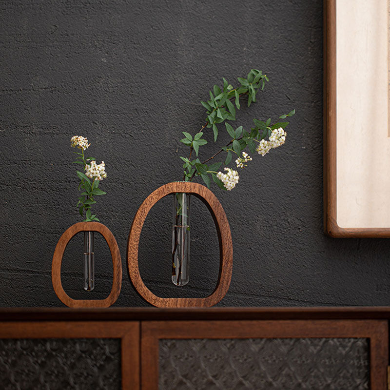 Two wooden wall-mounted vases with plants against a dark gray wall.