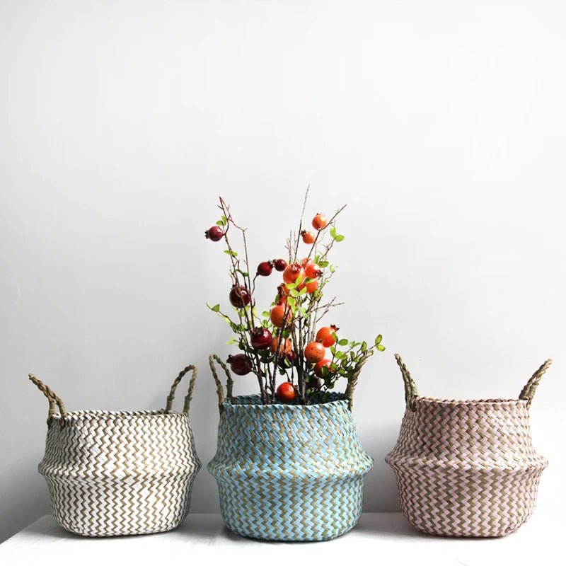 Three woven baskets with handles on a white surface against a light gray background