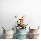 Three woven baskets with handles on a white surface against a light gray background